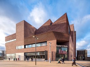 Sadler’s Wells East - Architects O’Donnell + Tuomey Brick building with angular roof structures, labeled