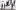 Compañia Jesus Carmona © Luka Radikovic Eight men, all in black polo neck tops and trousers, feet bare, stand in a street in front of a whitewashed wall. Seven face to the right, in identical pose, hands at their sides, heads turned towards us. One dancer stag leaps in the other direction, arms lifted above his head, knees bent up.