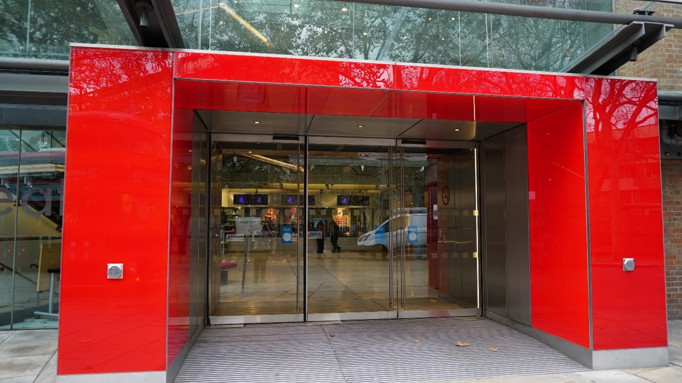 The red front entrance doorway of Sadler's Wells Theatre with glass doors