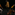 Three people perform a dynamic dance on a dark stage; one kneels with an arm raised, another stands facing forward, and the third balances on one leg.